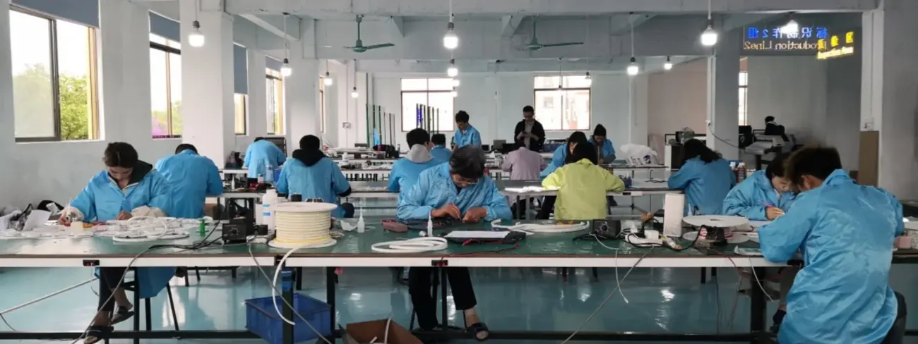 Team of workers crafting custom neon signs in a professional China workshop