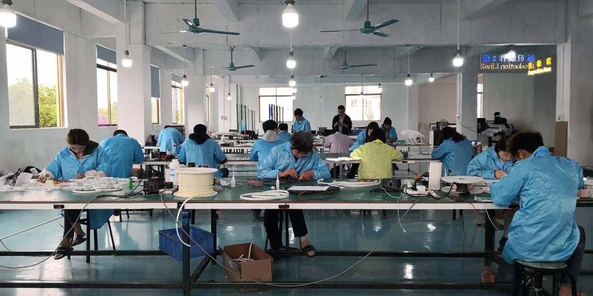 Team of workers crafting custom neon signs in a professional China workshop