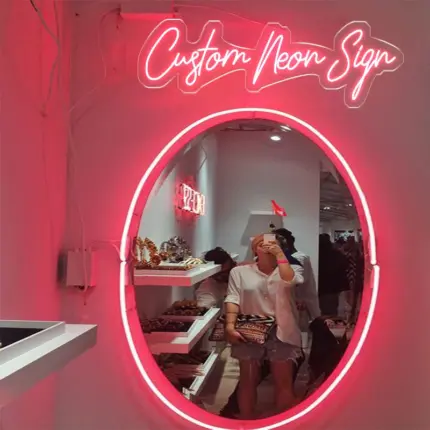 Oval mirror framed with pink neon light, creating a personalized mirror with neon decor.