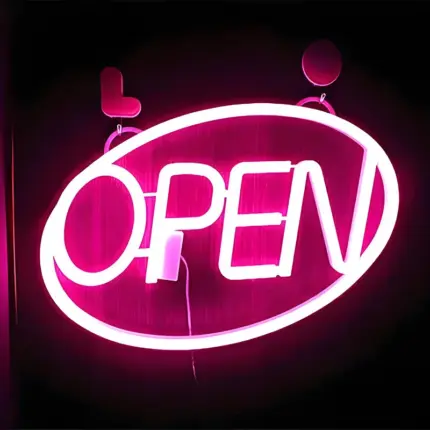 Pink red open letter neon lights for business storefront signage.